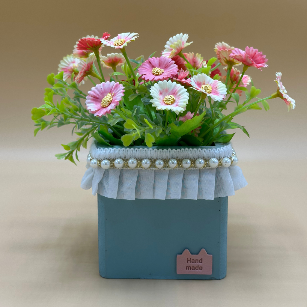 Charming Faux Pink Daisy Arrangement in Lace-Trimmed Teal Pot with Scented Candle